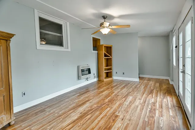 a view of a livingroom with wooden floor and a ceiling fan