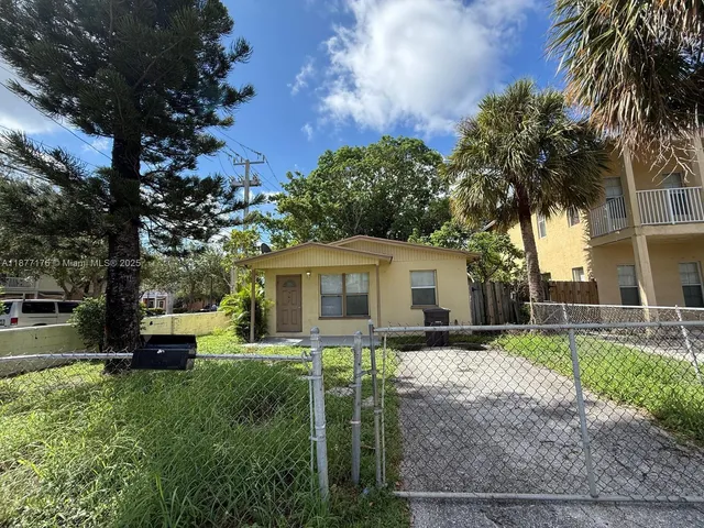 a yellow house with trees in front of it