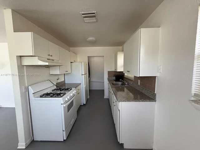 a kitchen with stainless steel appliances white cabinets and a stove