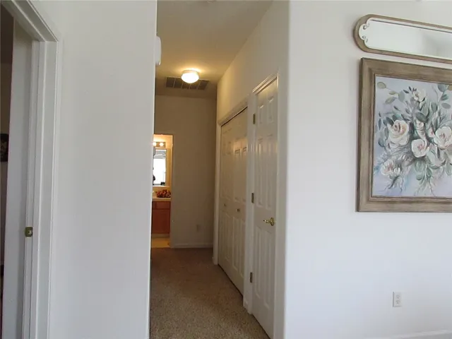 a view of a hallway with wooden shelves