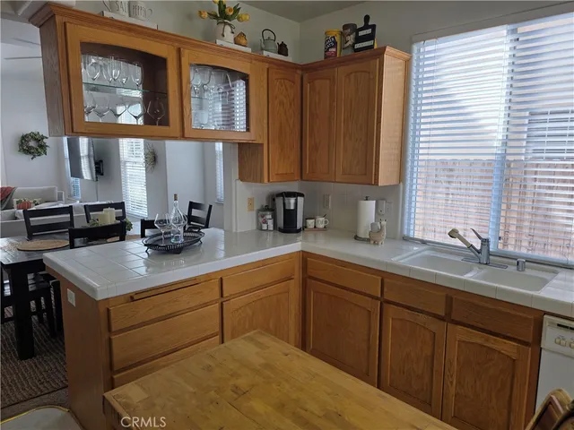 a kitchen with stainless steel appliances granite countertop a sink dishwasher a stove a dining table and chairs with wooden floor