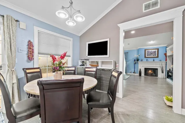 a dining room with furniture a livingroom with furniture a fireplace a flat screen tv and a fireplace