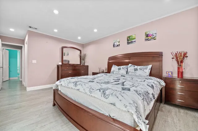 a spacious bedroom with a bed and a dresser