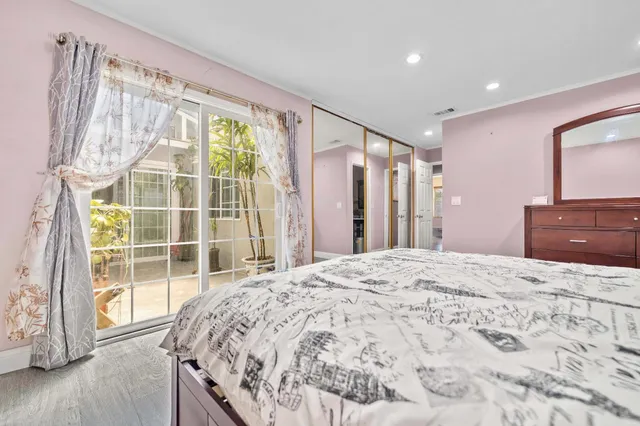 a bed sitting in a spacious bedroom next to a window