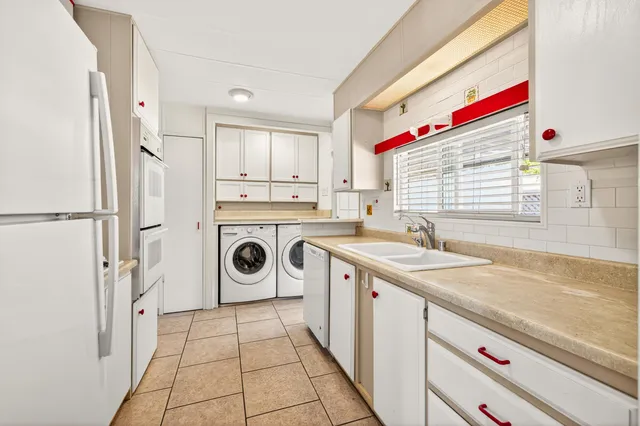 a kitchen with a sink and chairs