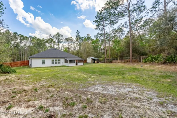 a view of a house next to a big yard with large trees