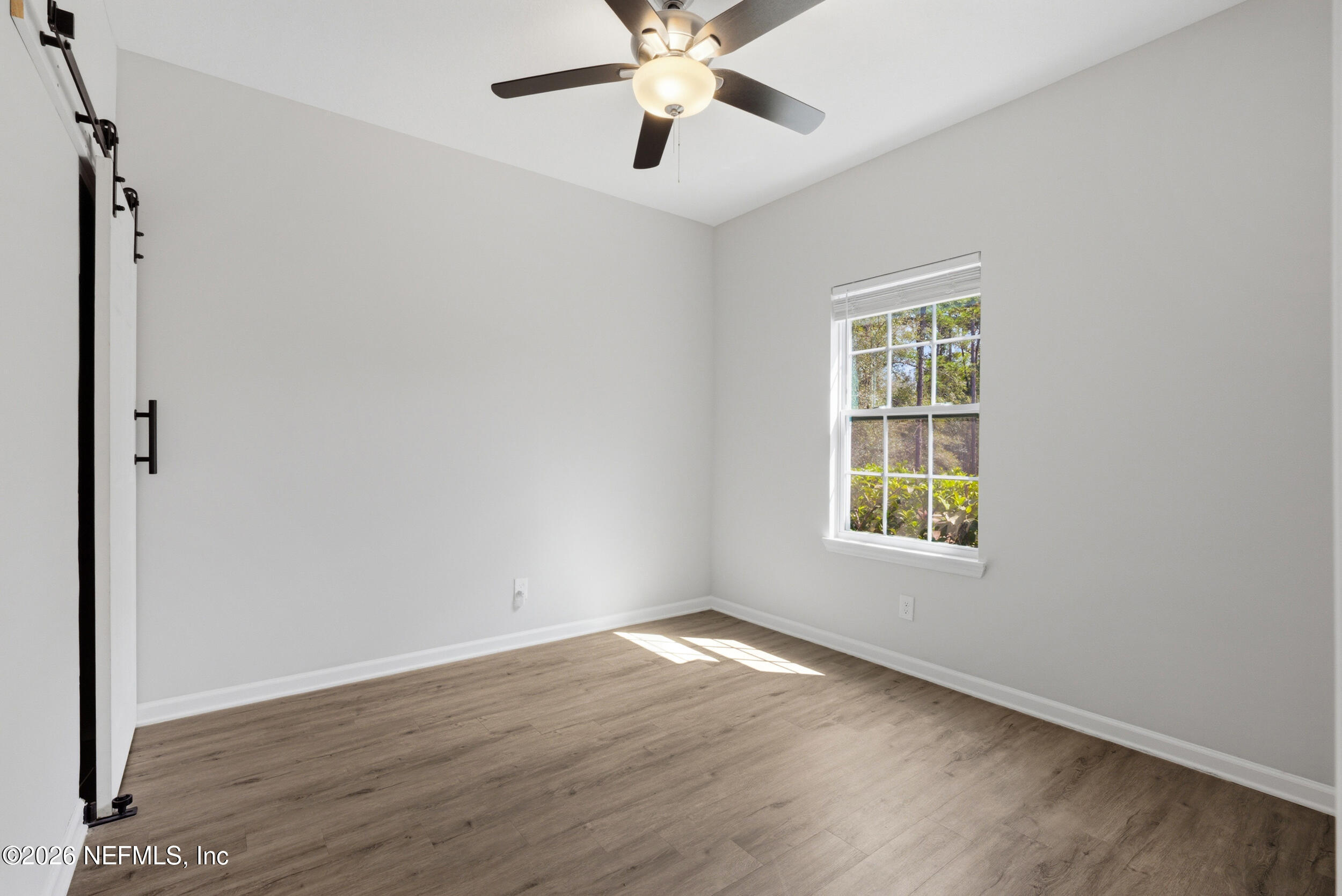94 Sorrel Street Middleburg, FL 32068 - Photo 5 of 40 an empty room with wooden floor chandelier fan and windows