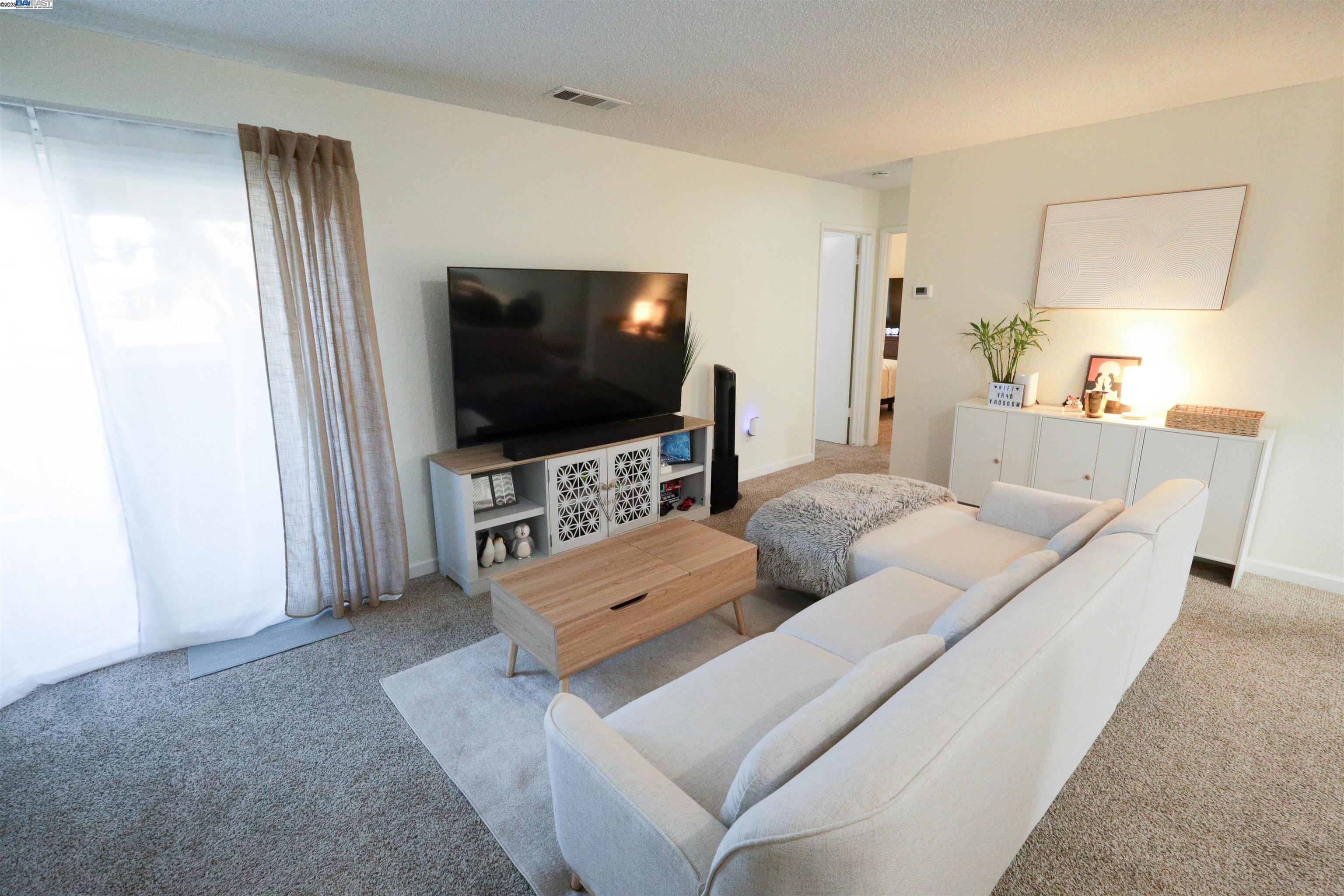 480 Cherry Lane, Unit E Manteca, CA 95337 - Photo 2 of 11 a living room with furniture and a flat screen tv