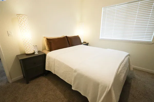 a bed sitting in a bedroom next to a window