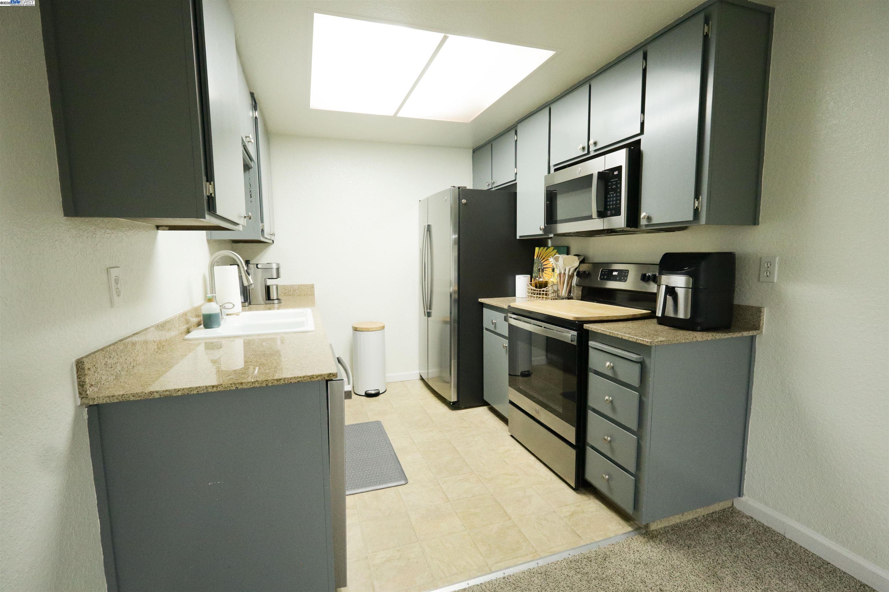 480 Cherry Lane, Unit E Manteca, CA 95337 - Photo 7 of 11 a kitchen with stainless steel appliances granite countertop a sink stove and refrigerator