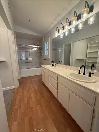 a bathroom with a double vanity sink mirror and shower