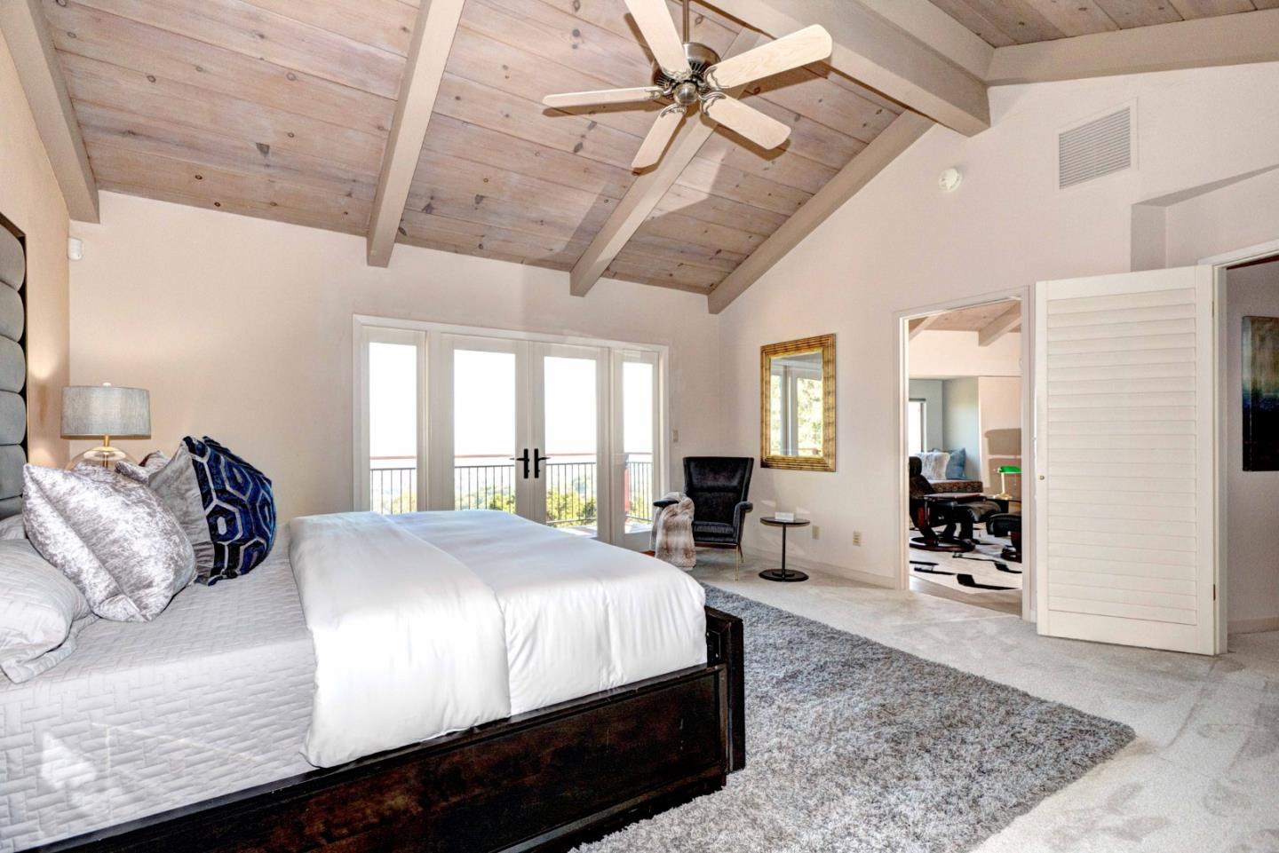 22365 Regnart Road Cupertino, CA 95014 - Photo 24 of 54 a large bedroom with a bed a dresser and wooden floor