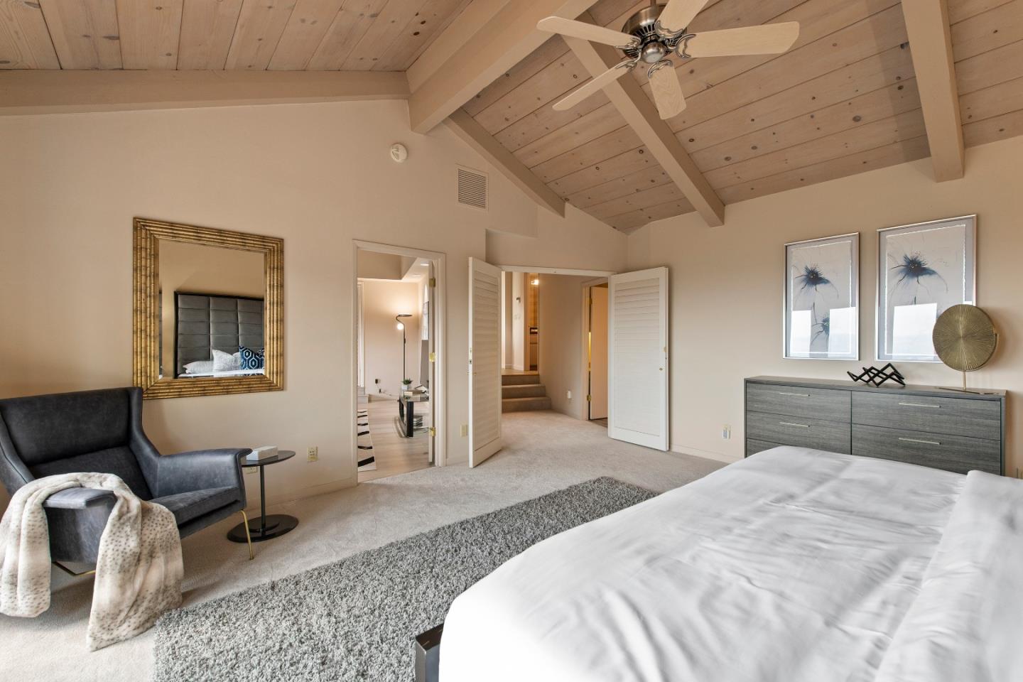 22365 Regnart Road Cupertino, CA 95014 - Photo 25 of 54 a spacious bedroom with a bed a couch and dresser