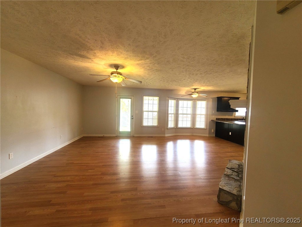 6521 Applewhite Road Fayetteville, NC 28304 - Photo 3 of 22 a view of empty room with wooden floor and fan