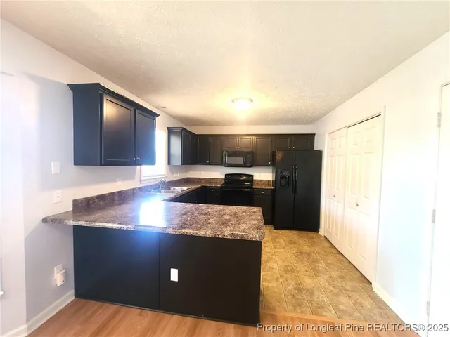 a kitchen with kitchen island granite countertop cabinets and refrigerator