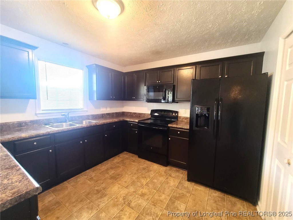 6521 Applewhite Road Fayetteville, NC 28304 - Photo 7 of 22 a kitchen with a refrigerator and a sink
