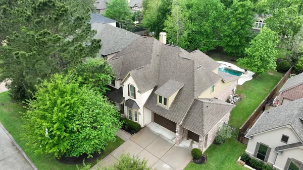 a front view of a house with a garden and trees