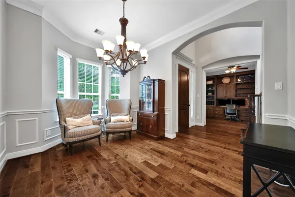 a dining room with furniture a chandelier a kitchen view and a chandelier