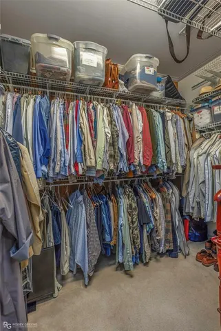 a view of walk in closet with clothes and shoes