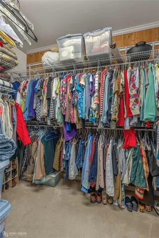 a view of walk in closet with clothes