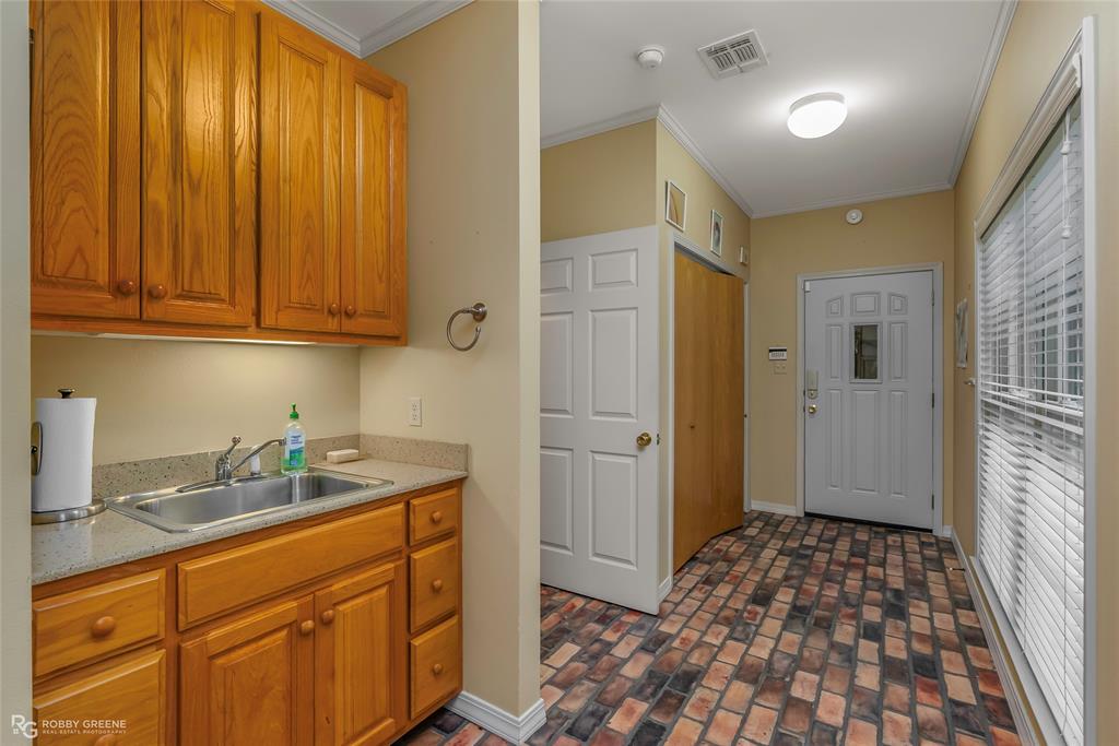 3100 Herren Road Doyline, LA 71023 - Photo 28 of 40 a kitchen with a sink and wooden cabinets