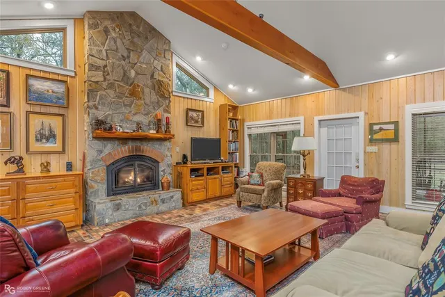 a living room with furniture a flat screen tv and a fireplace