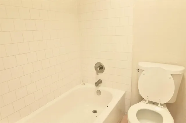 a bathroom with a toilet and a bathtub