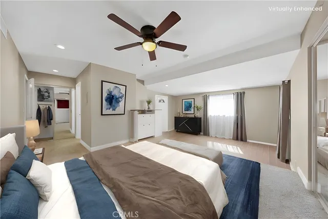 a spacious bedroom with a large bed and a chandelier