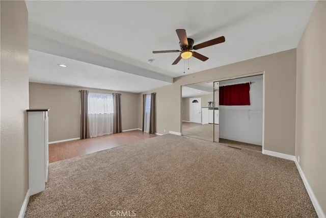 a view of a livingroom with a ceiling fan and window