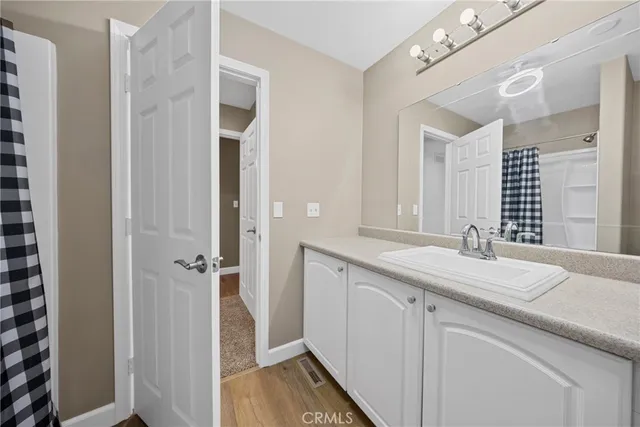 a en suite bathroom with a granite countertop sink and a mirror