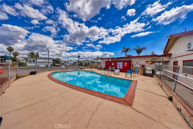 a view of a white house with a big yard and large tree