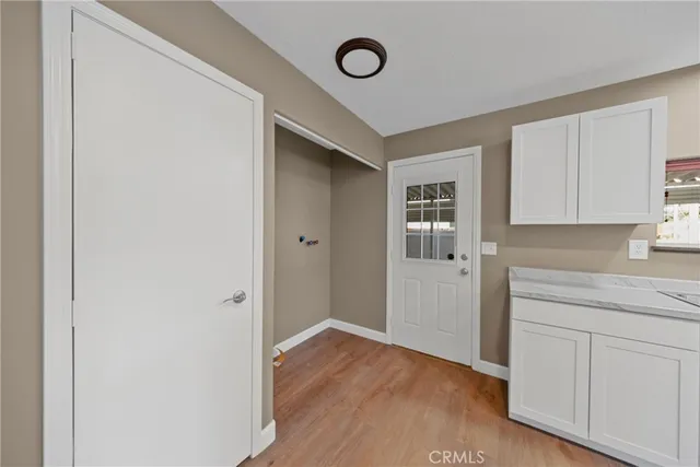 a view of empty room with window and wooden floor