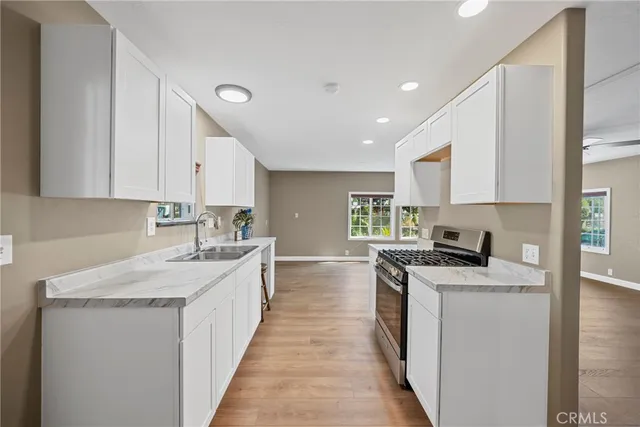 a kitchen with stainless steel appliances granite countertop a sink stove and cabinets