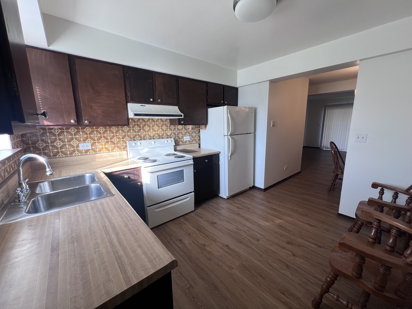 1779 Rand Road, Unit 1B Des Plaines, IL 60016 - Photo 2 of 8 a kitchen with stainless steel appliances wooden floors wooden cabinets a sink and a stove