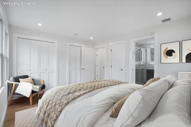 a spacious bedroom with a bed and a lamp