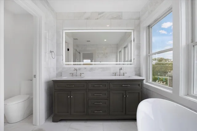 a spacious bathroom with a granite countertop sink mirror and a bathtub