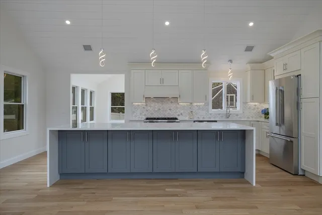 a kitchen with stainless steel appliances granite countertop a refrigerator and a sink