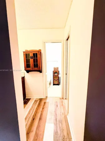 a hallway with stairs and wooden floor