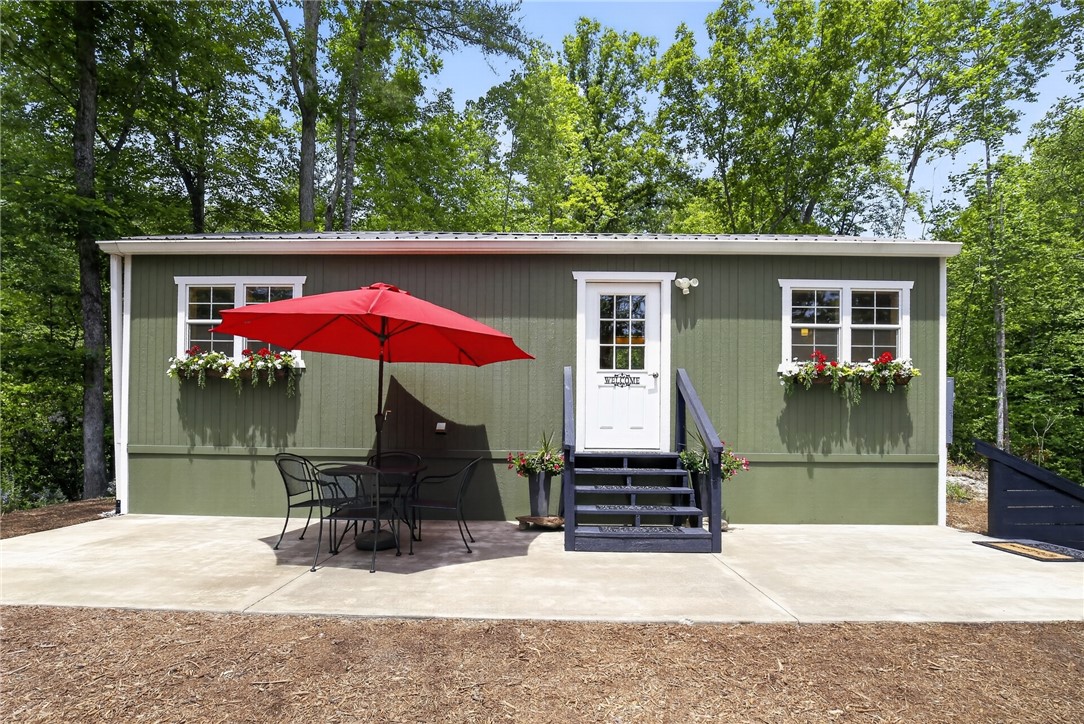 400 Mill Creek Road Sunset, SC 29685 - Photo 1 of 8 A charming green siding home with inviting front steps and a spacious patio area for outdoor enjoyment.