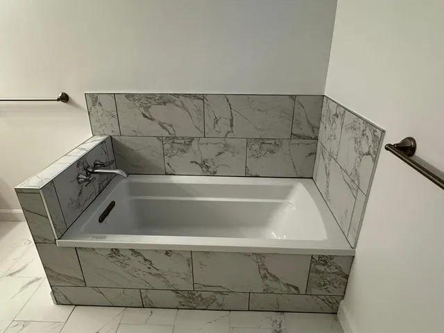 a spacious bedroom with a bed a table and chair