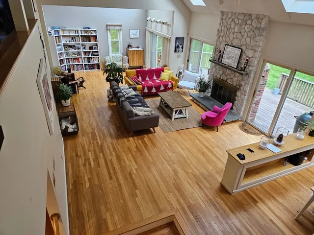 a living room with furniture a fireplace and a floor to ceiling window