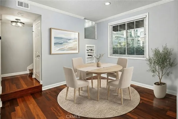 a dining room with furniture potted plants and wooden floor