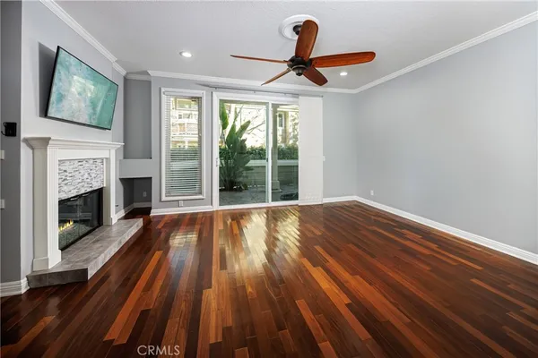 a view of empty room with wooden floor and fireplace