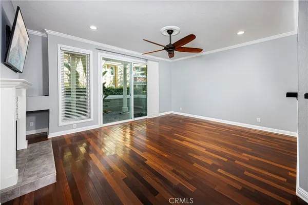 a view of a livingroom with a fireplace a ceiling fan and window