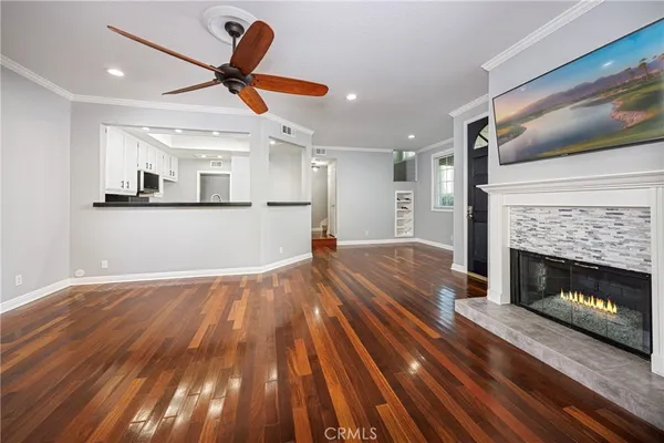 a view of empty room with wooden floor fireplace and ceiling fan