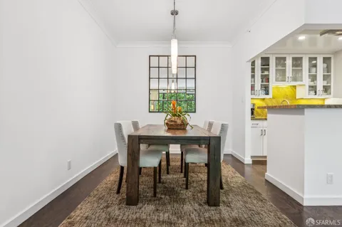 a dining room with furniture a rug and a mirror