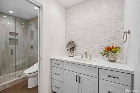 a bathroom with a sink a toilet and shower