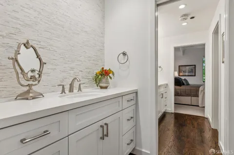 a en suite bathroom with a granite countertop sink and a mirror