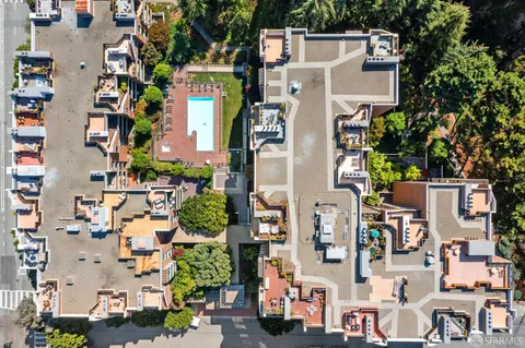 an aerial view of multi story residential apartment building with outdoor space and parking area