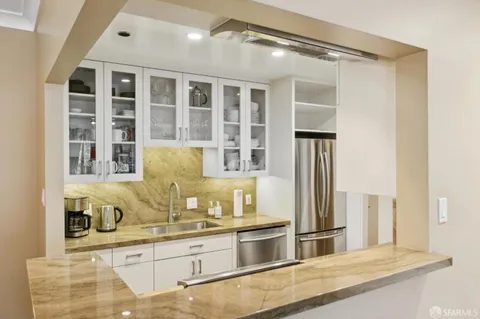 a kitchen with stainless steel appliances granite countertop a sink and refrigerator